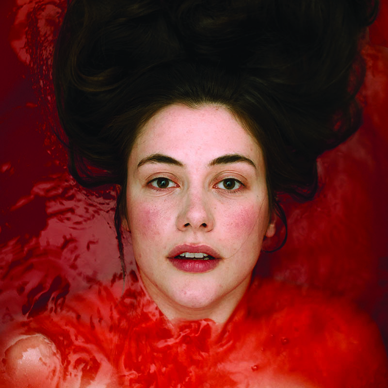 Photo of Marjolein Robertson submerged in red water apart from her face