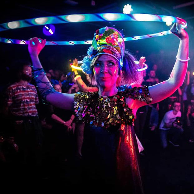 Picture of someone in a disco holding a hula hoop above their head
