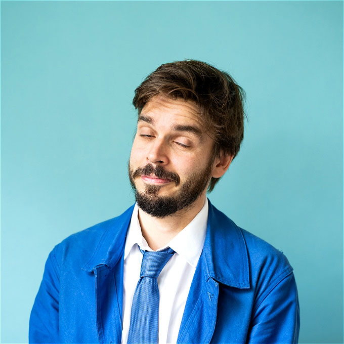 Photo of Joz Norris wearing a blue jacket and tie