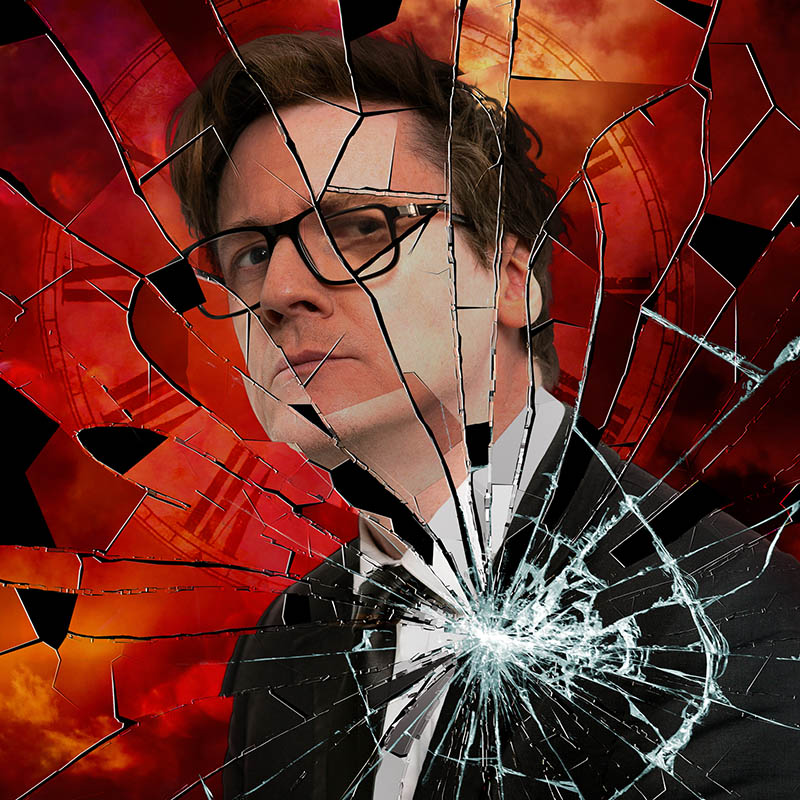 Photo of Ed Byrne behind a shattered pane of glass