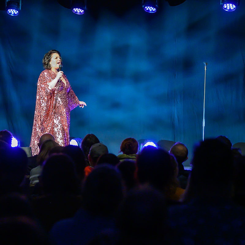 Photo of Kiri Pritchard-McLean on stage hosting a previous showcase