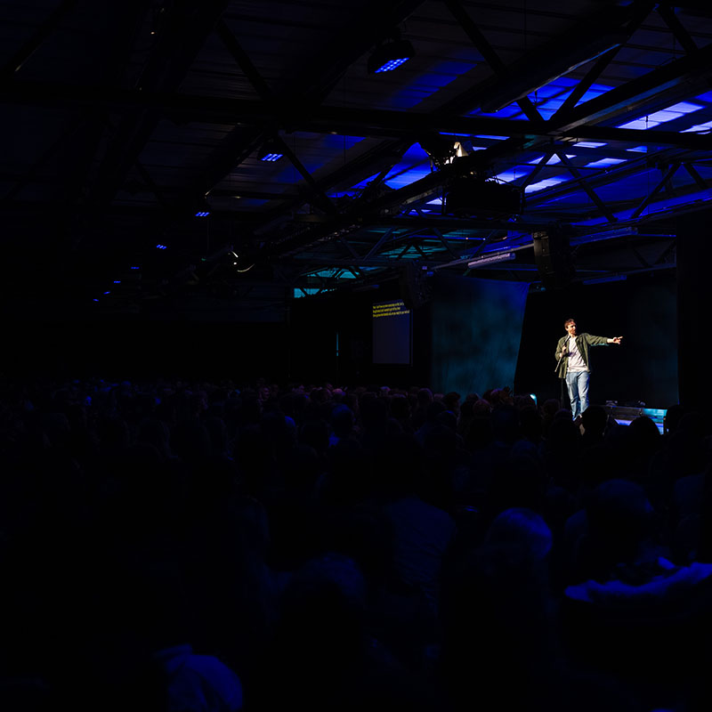 Photo of Ian Smith on stage hosting a previous showcase