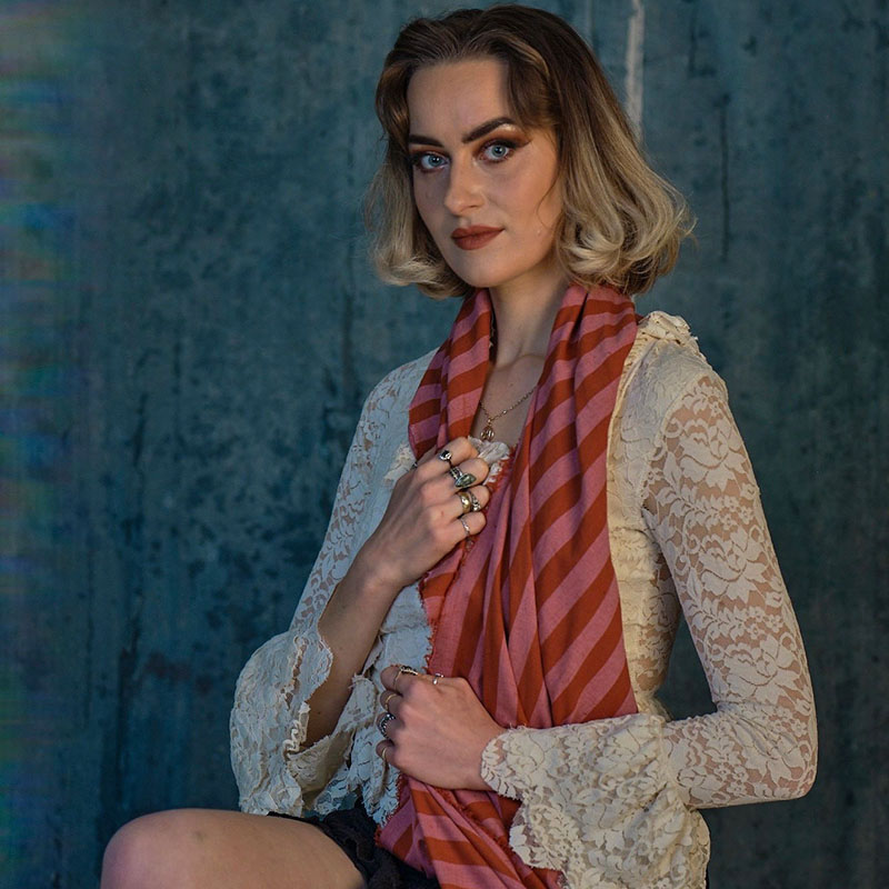 Photo of Amy Matthews sat upright on a stool