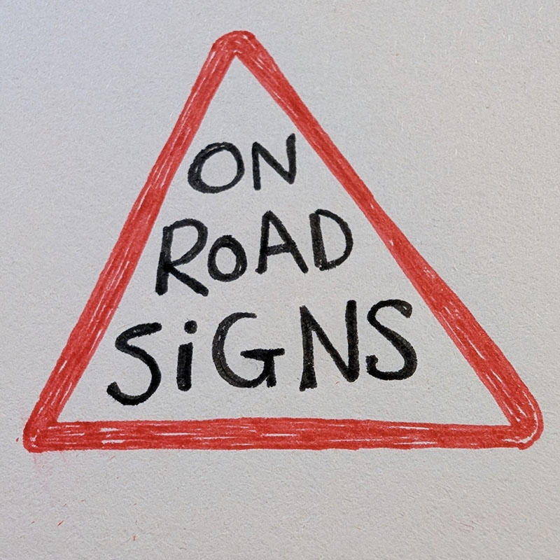 Hand drawn red triangle with ON ROAD SIGNS written inside