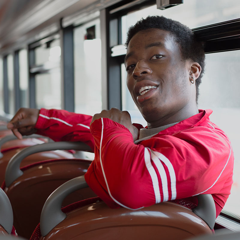 Photo of Ayo Adenekan sat on a bus seat