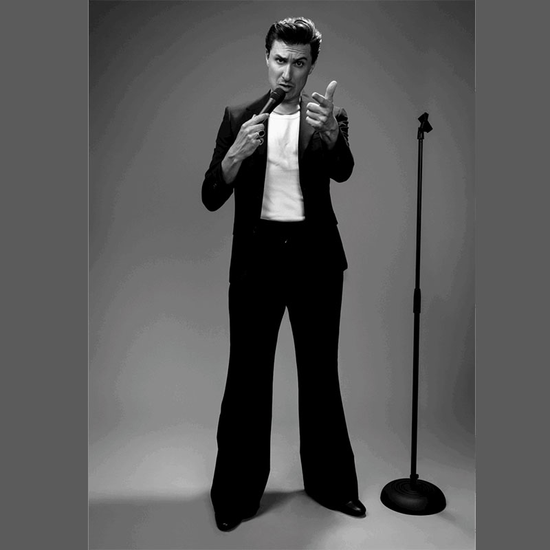 Tom Rosenthal dressed and styled to look like Alex Turner from the Arctic Monkeys