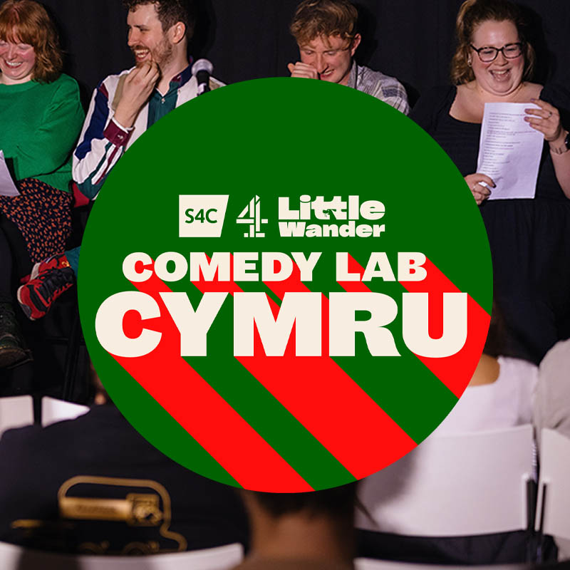 Comedy Lab Cymru logo over the top of a picture of performers on stage at a previous event
